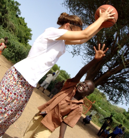 Maria plays with one of her young students during a basketball tournament.